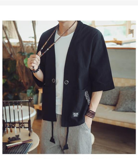 Person wearing a black kimono-style jacket in a casual indoor setting 