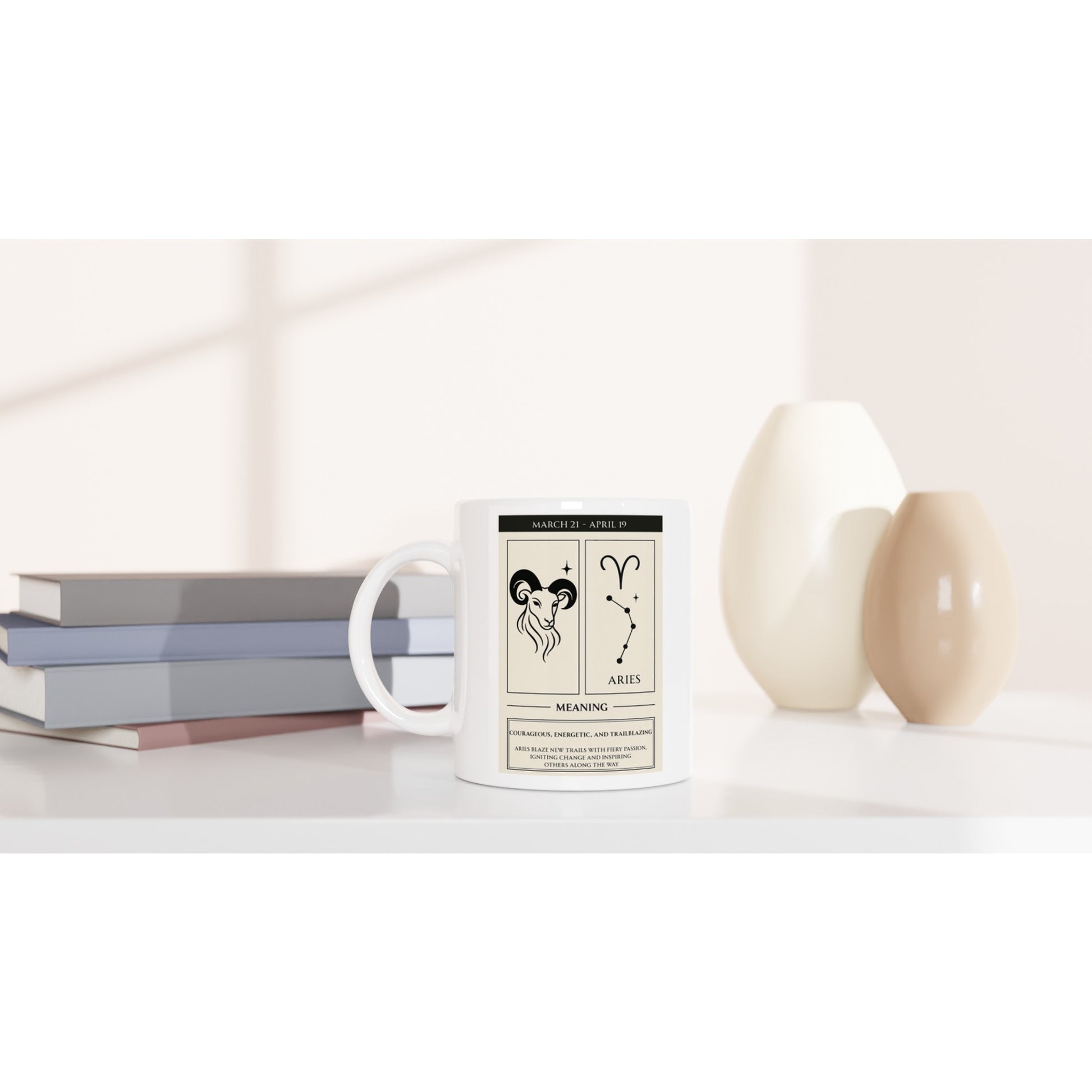 Mockup of a white ceramic mug featuring the Aries zodiac poster design (ram illustration, glyph, constellation, dates, and meaning) on a white tabletop, with stacked books and beige vases softly blurred in the background.