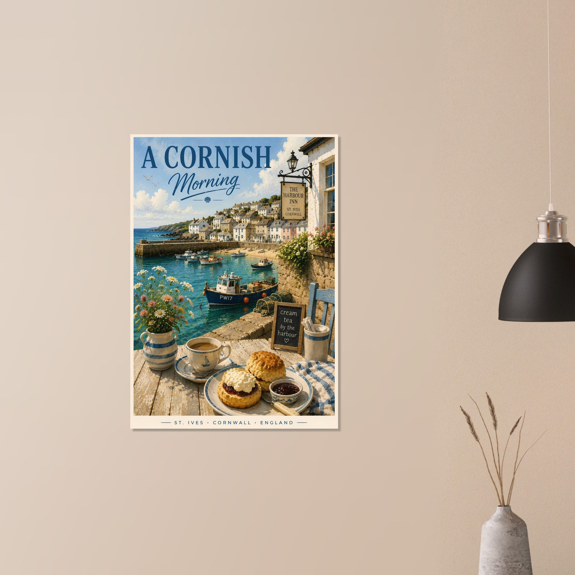 Poster of a Cornish coastal scene with a village, harbor, and tea set on a beige wall.