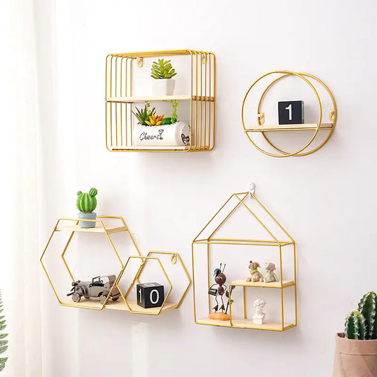 Set of gold geometric wall shelves with decorative items on a white wall.