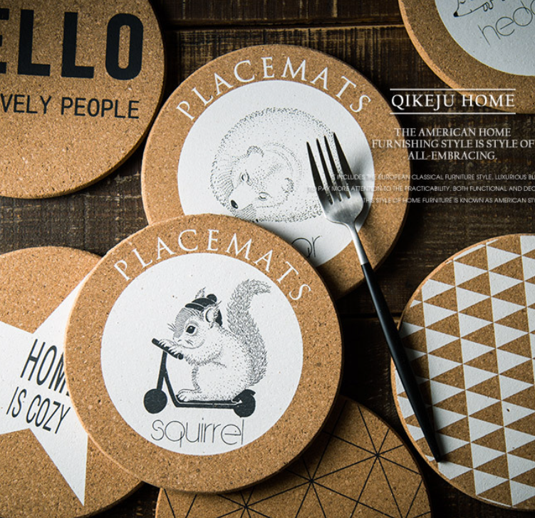 Round cork placemats with illustrations and text on a wooden surface.