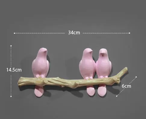 Three pink bird figurines on a branch with measurements indicated.
