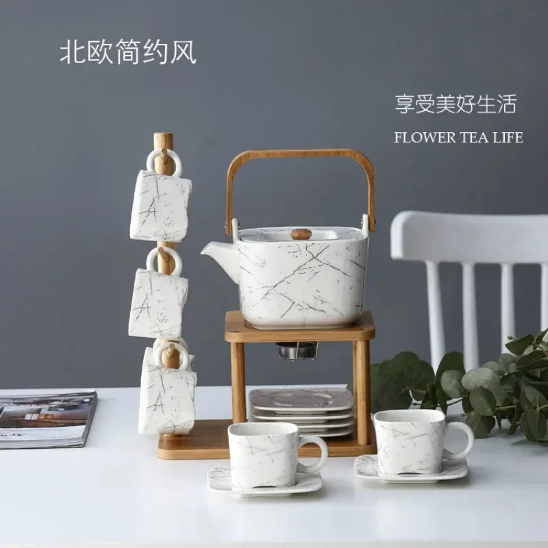 Tea set with marble design on a wooden stand against a gray background