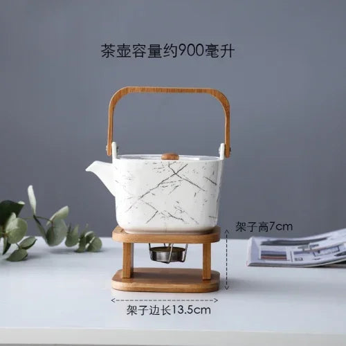 White ceramic teapot with wooden handle and stand on a gray background