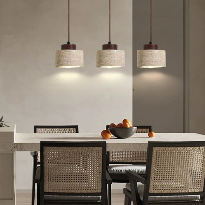 Dining area with pendant lights, table, and chairs in a modern setting.
