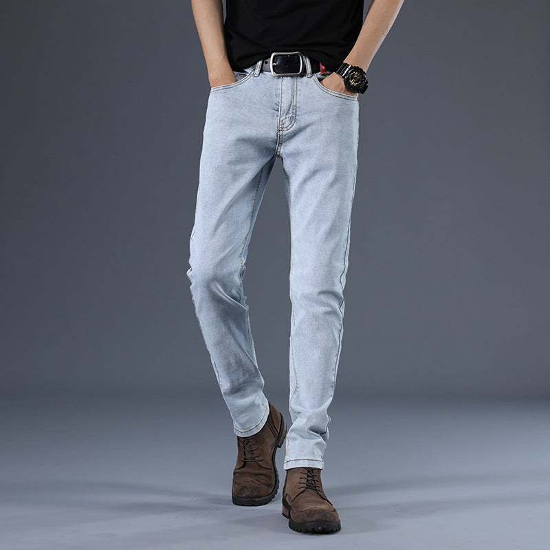 Person wearing light blue jeans and brown boots on a gray background