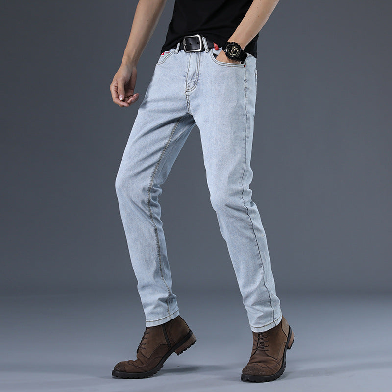 Person wearing light blue jeans and brown boots on a gray background