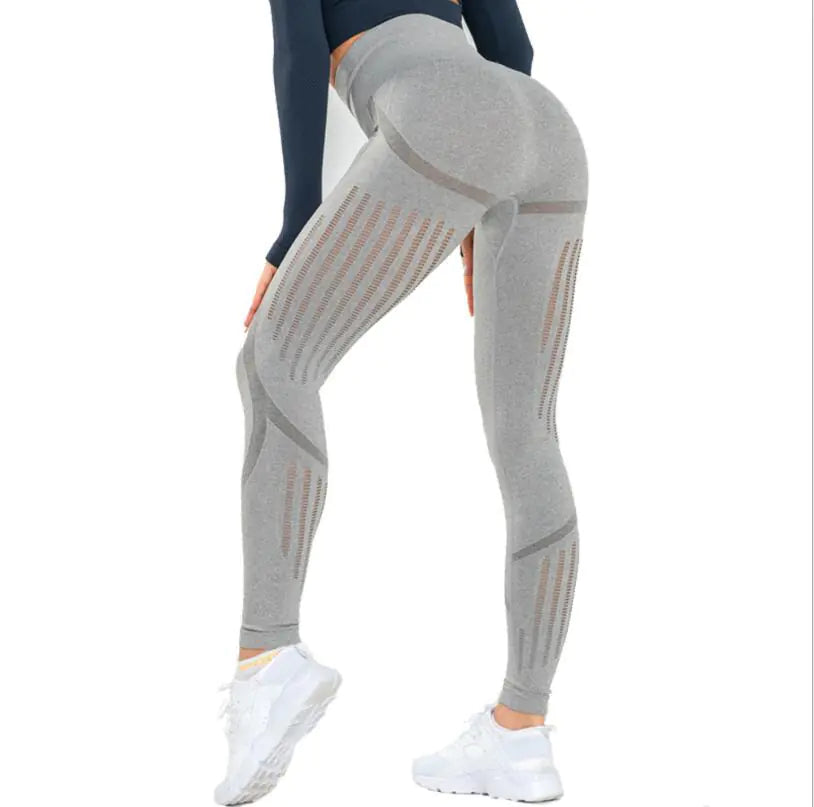 Gray leggings with mesh panels worn by a person on a white background