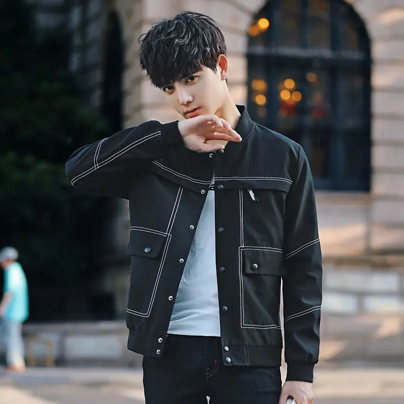 Man wearing a black jacket with white accents in an urban setting