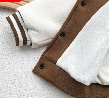 Close-up of a brown and white jacket with buttons on a textured surface