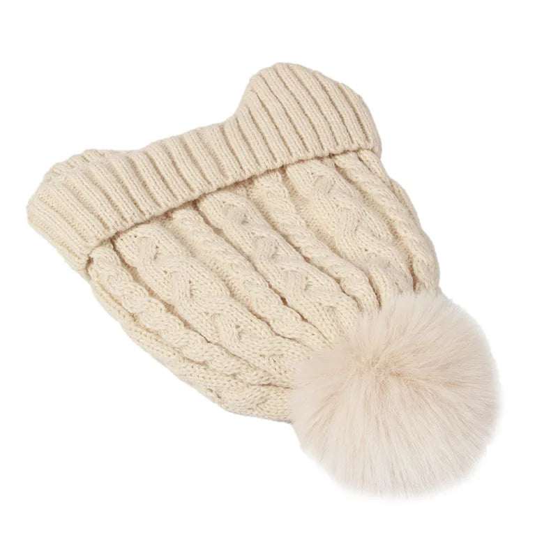 Beige knitted pet sweater with a pom-pom on a white background