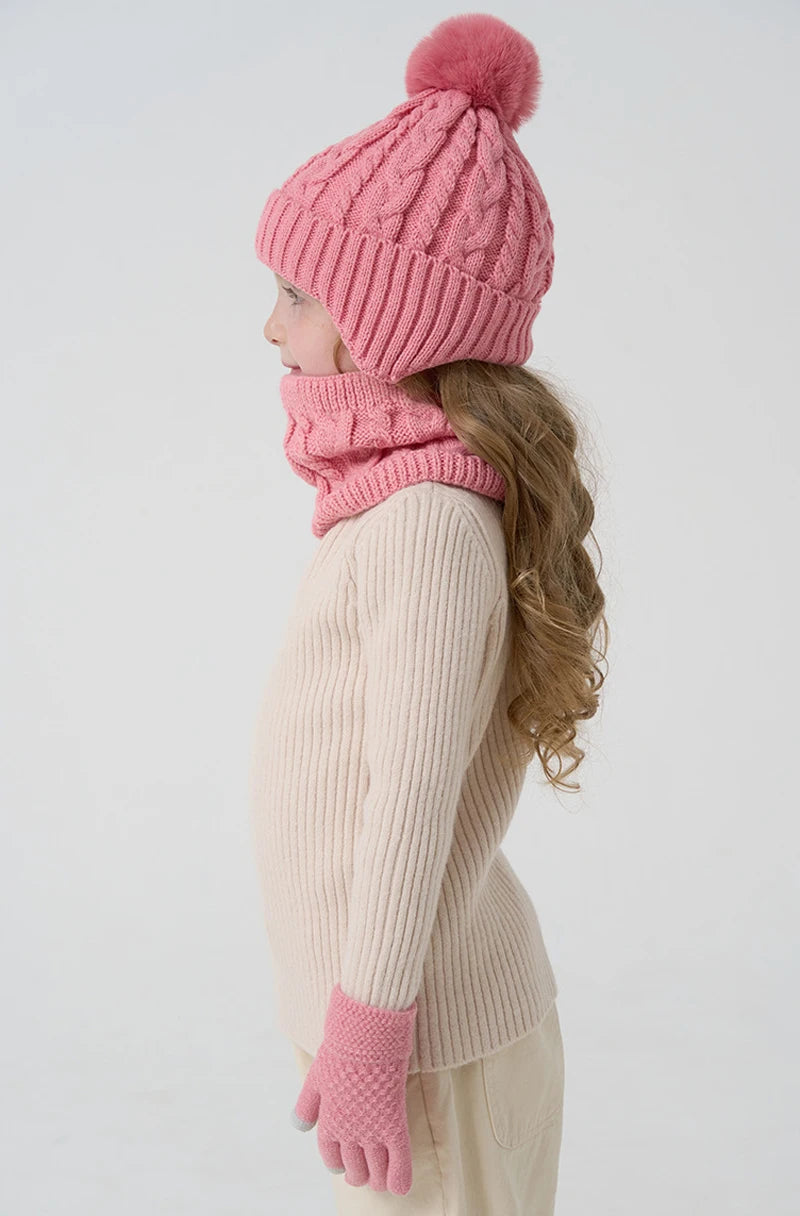 Person wearing a pink knitted hat, scarf, and gloves on a white background