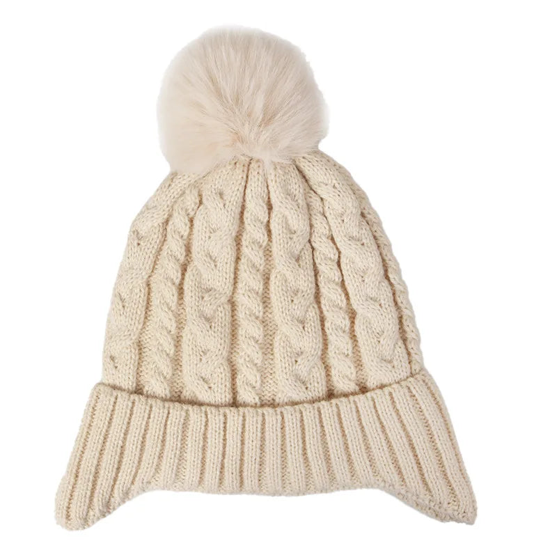 Beige knitted beanie with a pom-pom on a white background