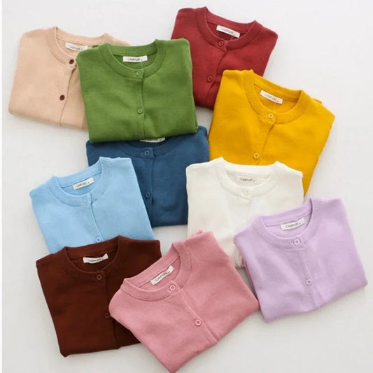 Assorted colorful baby cardigans on a white background