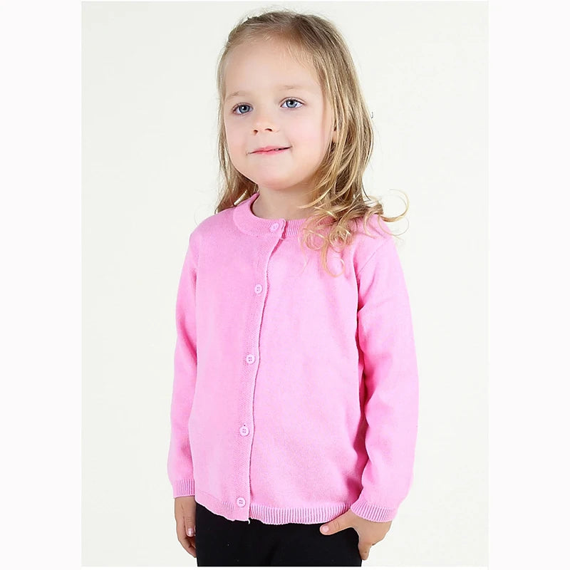 Young girl wearing a pink cardigan on a white background