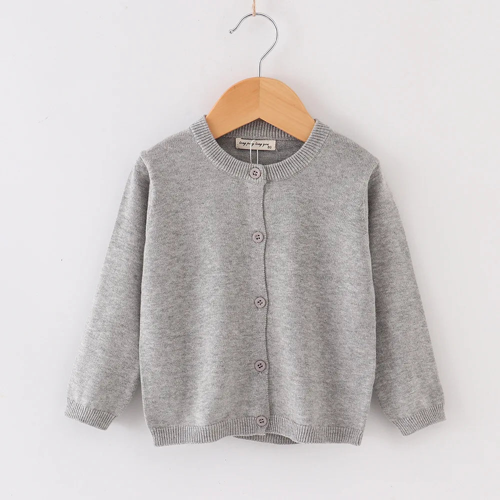 Gray children's cardigan on a wooden hanger against a white background