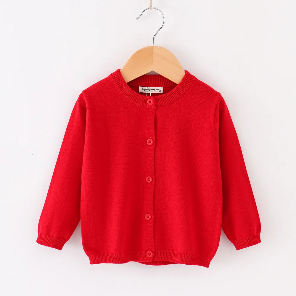 Red cardigan on a wooden hanger against a white background