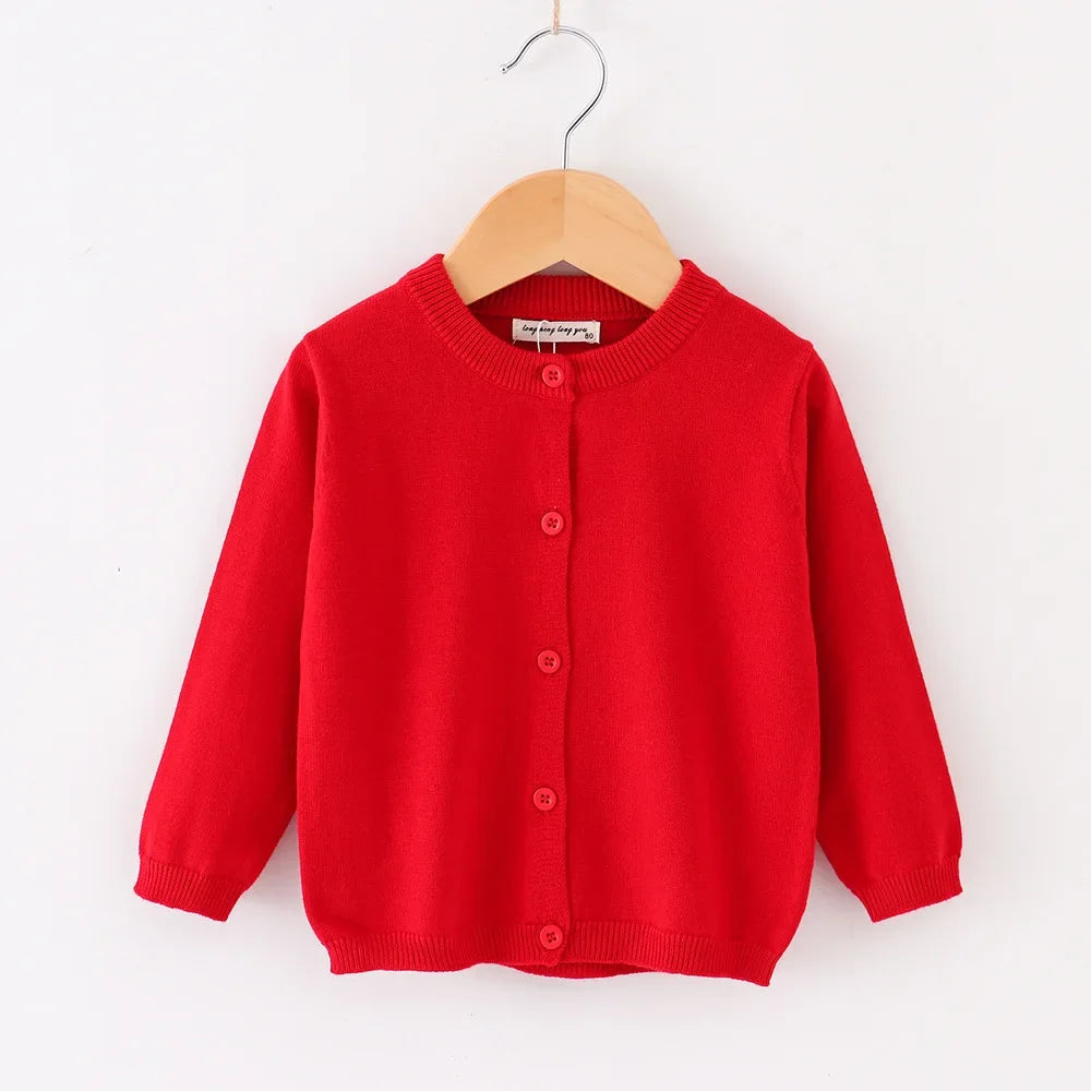 Red cardigan on a wooden hanger against a white background