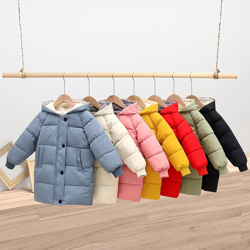 Row of colorful children's puffer jackets on hangers against a light background