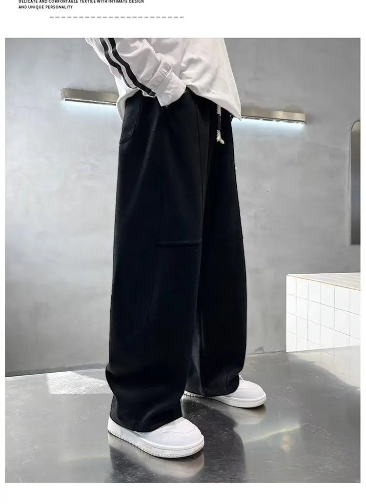 Person wearing black pants and white shoes in a minimalistic setting