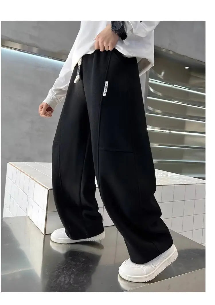 Person wearing black pants and white shoes in an urban setting