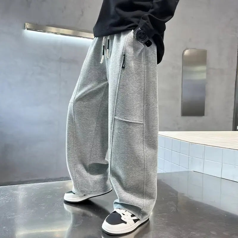 Person wearing gray sweatpants in a modern indoor setting