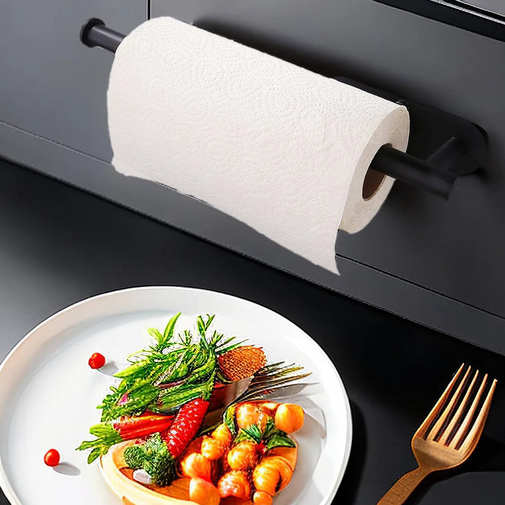 Roll of paper towel on a holder above a plate of food on a kitchen counter.