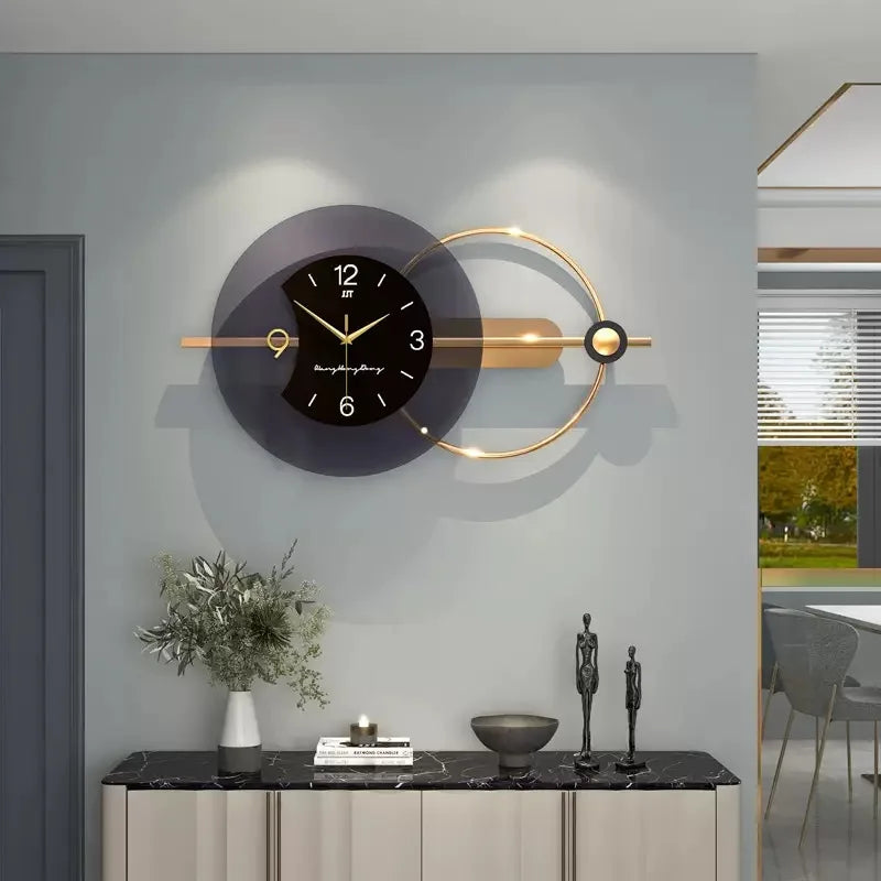 Modern wall clock with gold accents on a gray wall, with a decorative console table and plant in the foreground.
