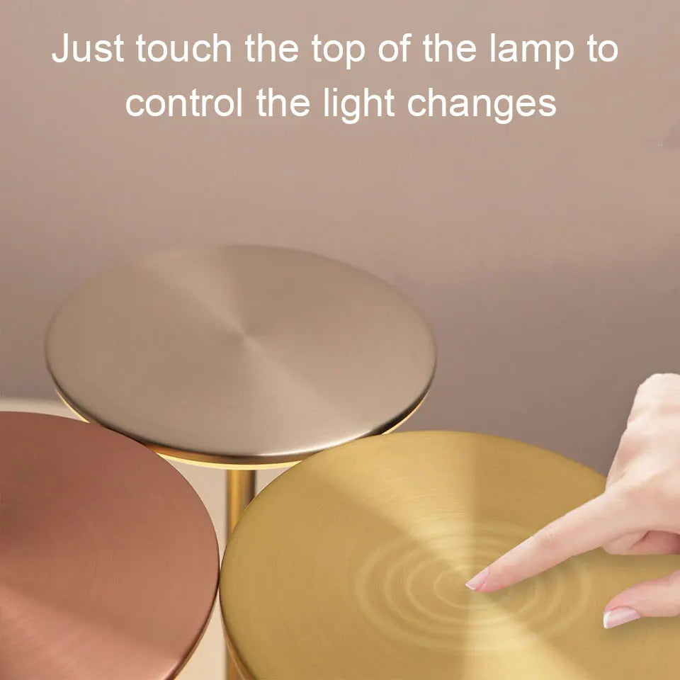 Gold lamp with text instructing to touch the top for light changes against a neutral background