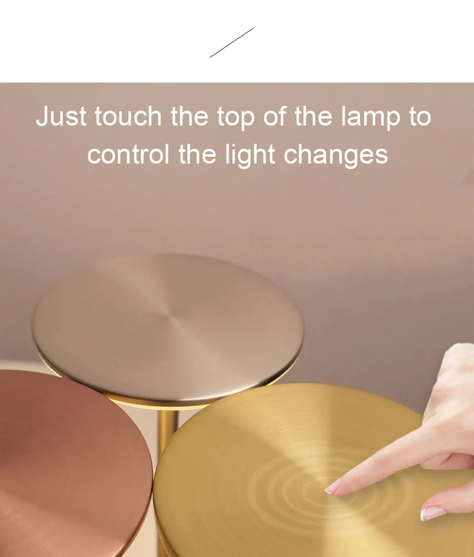 Gold lamp with text instructing to touch the top for light changes on a beige background