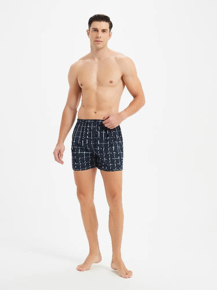 Man wearing navy patterned boxer briefs on a white background