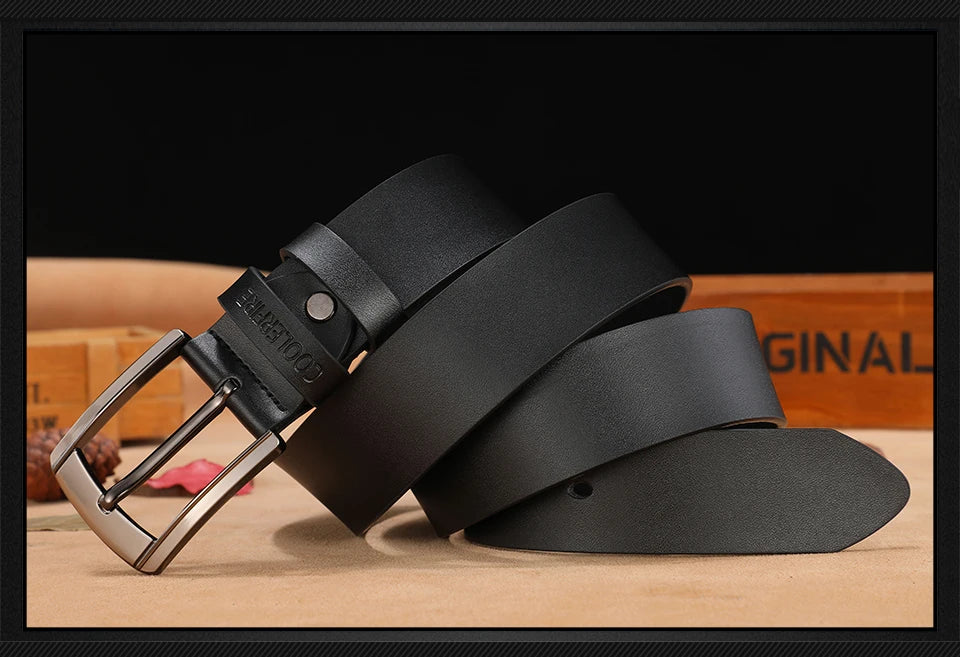 Black leather belt with a silver buckle on a wooden surface