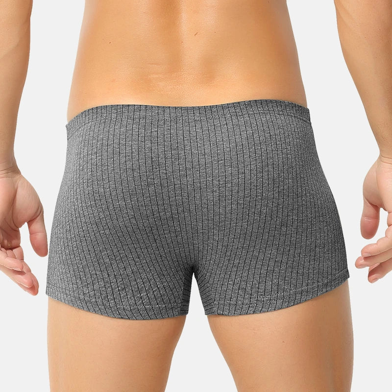 Person wearing gray textured boxer briefs on a plain background