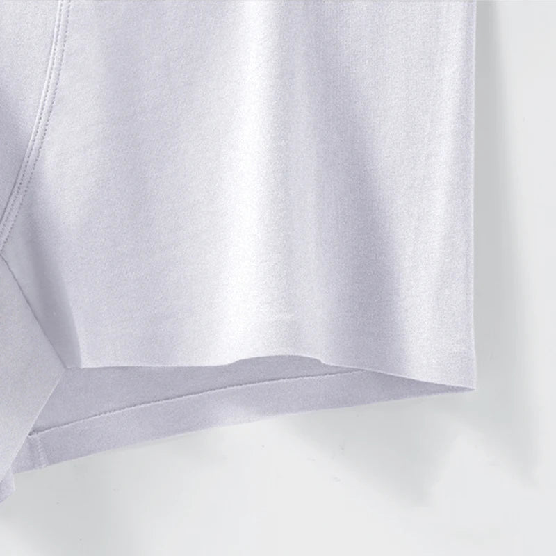 Close-up of a white fabric with a subtle pattern on a light gray background