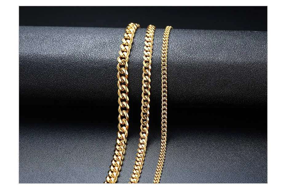 Two gold chain necklaces on a dark fabric background