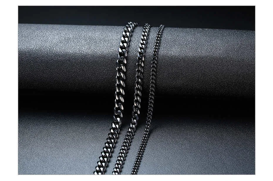Two silver chain necklaces on a dark gray fabric background