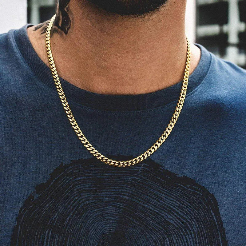Gold chain necklace worn by a person on a blue shirt