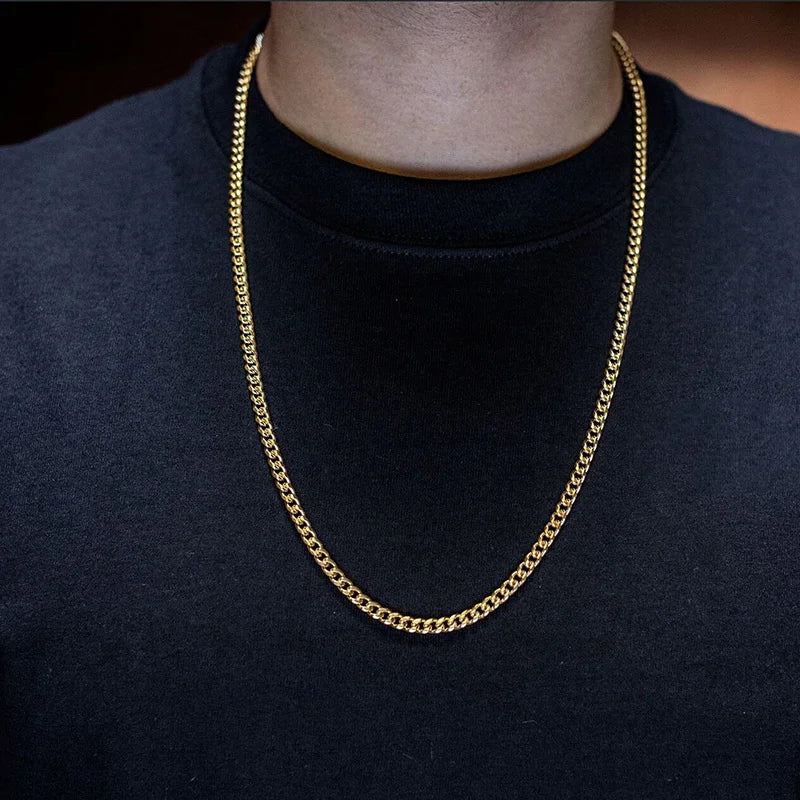 Gold chain necklace on a person wearing a black shirt