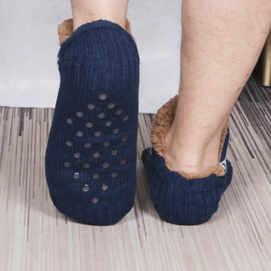Navy blue slippers with a fuzzy brown interior on a wooden floor.