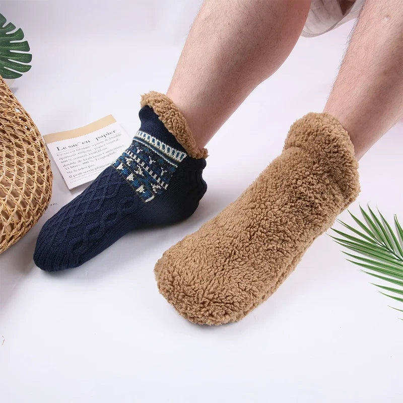 Navy and brown fuzzy socks on a white background with green leaves.
