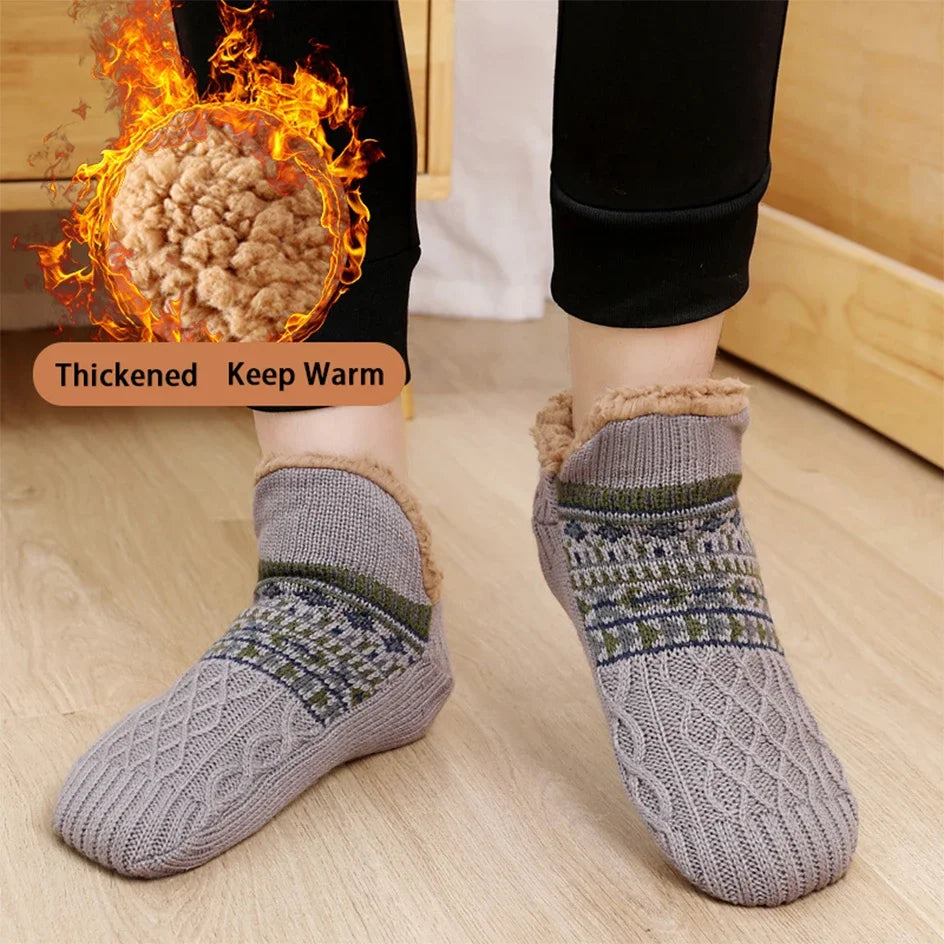 Gray patterned socks with thickened design for warmth on a wooden floor.