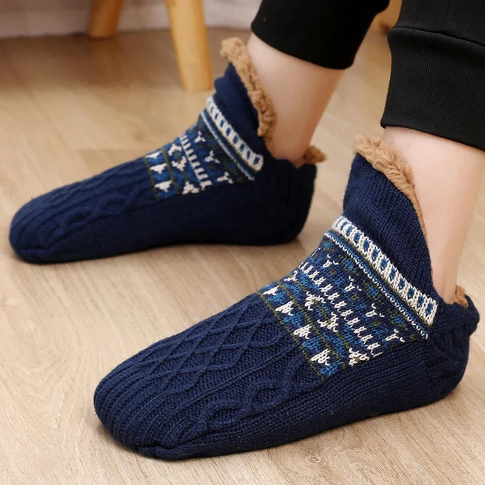 Navy blue patterned socks with brown trim worn on a wooden floor.
