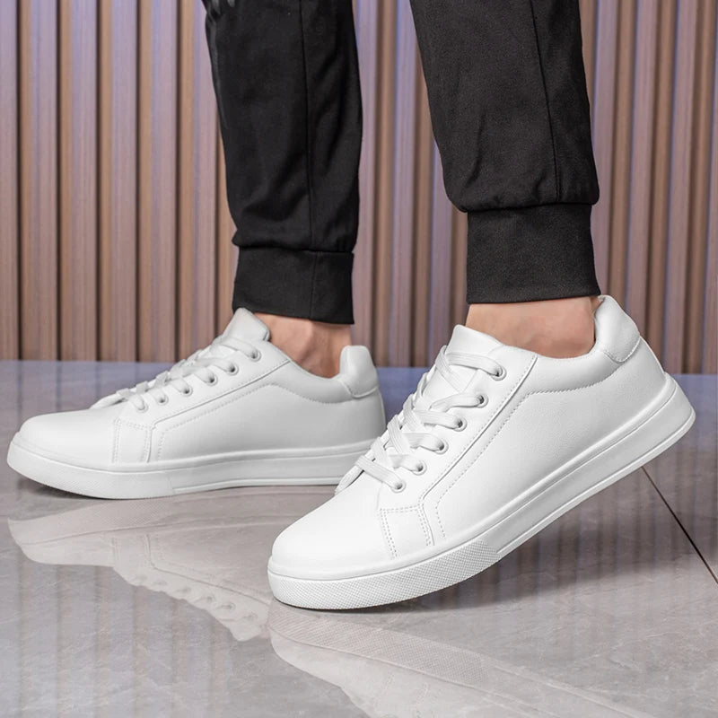 White sneakers worn with black pants on a neutral background