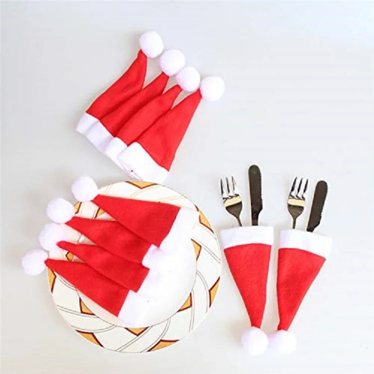 Red Santa hat napkins on a plate with cutlery on a white background
