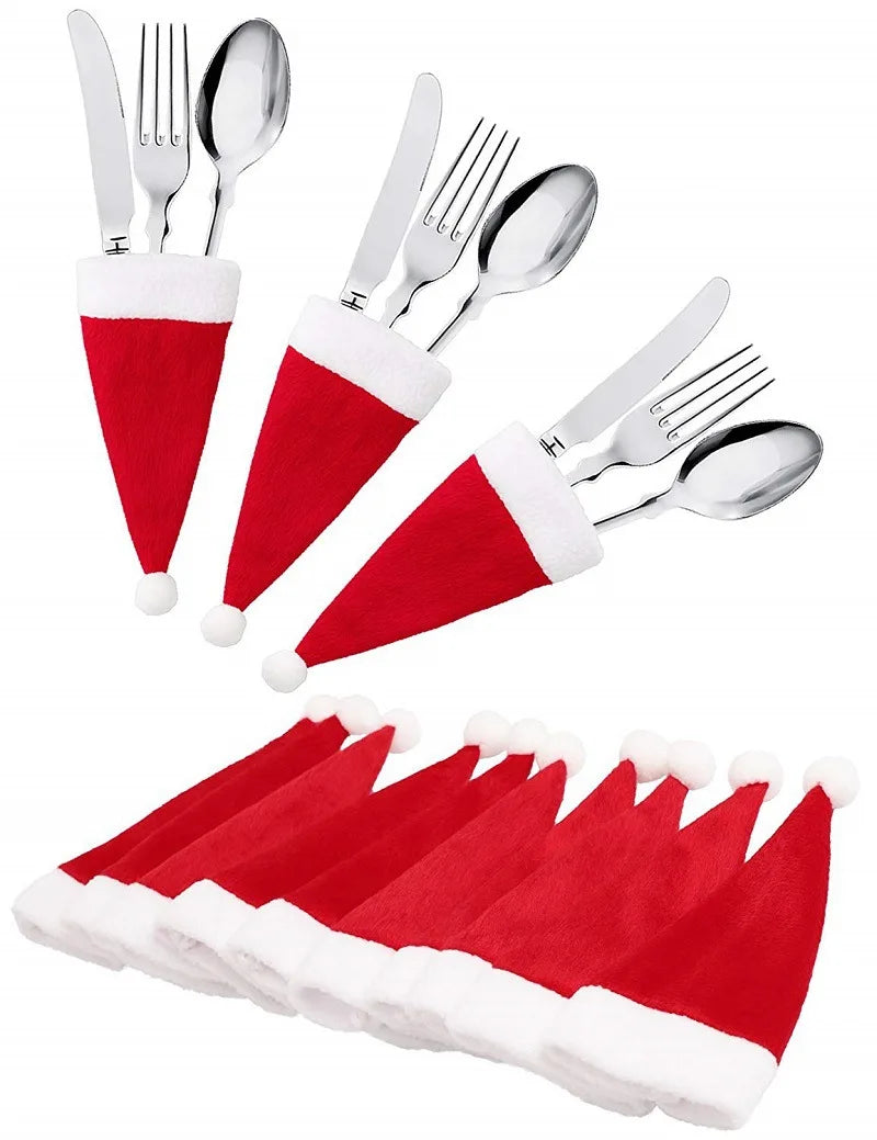 Set of silver cutlery with red and white Santa hats on a white background