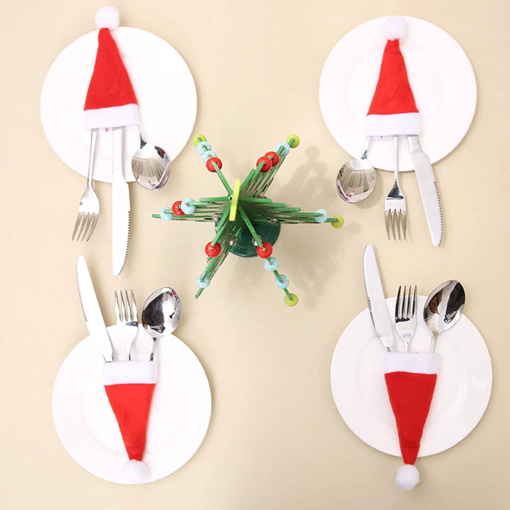 Set of Christmas-themed cutlery with Santa hats on a beige background