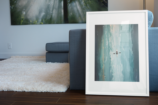 Framed artwork of a person kayaking on water in a living room setting.