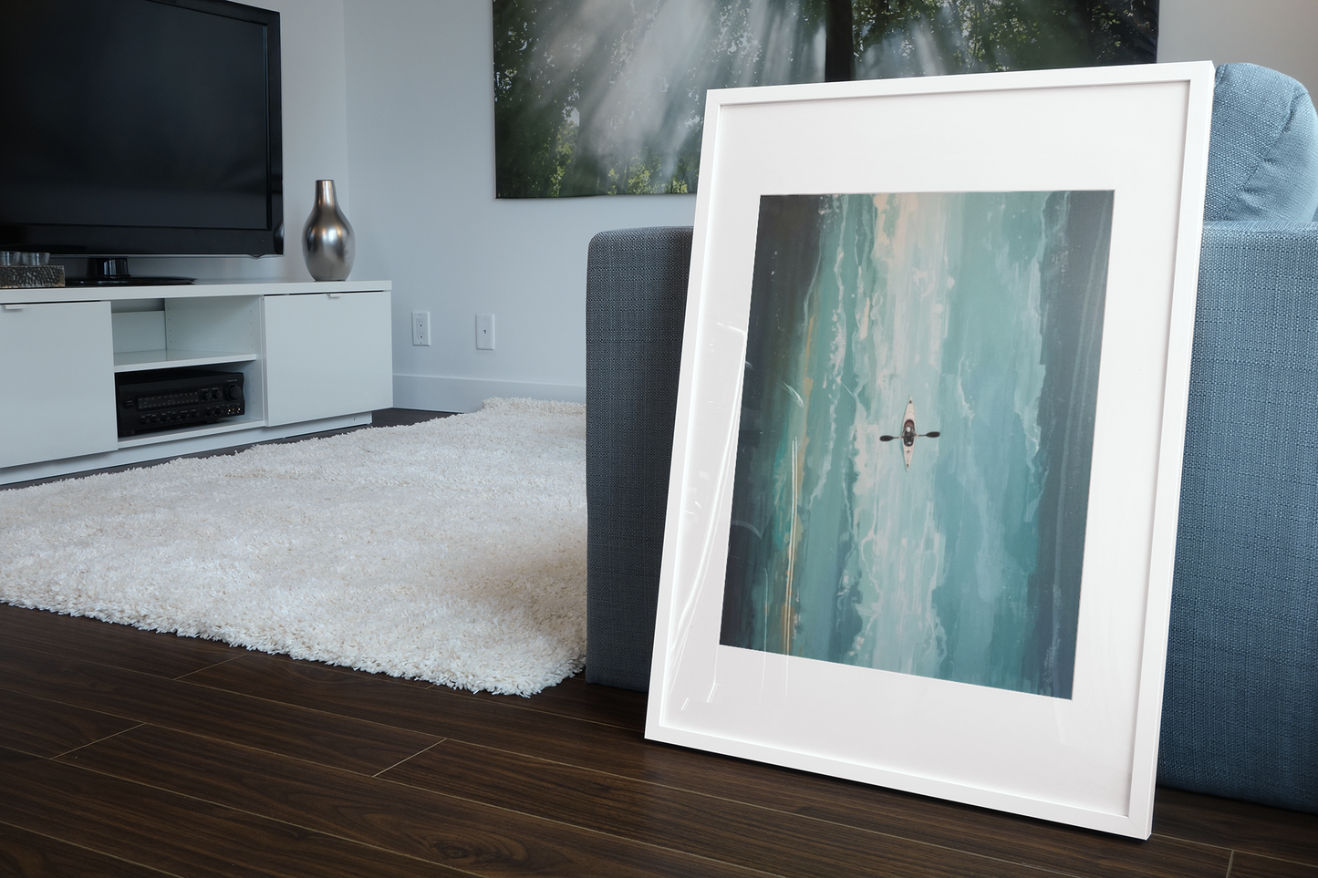 Framed artwork on a wooden floor in a living room setting