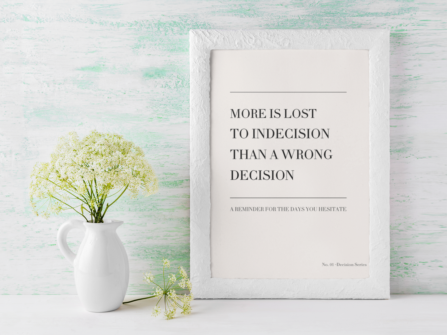Minimalist typography wall art with indecision quote styled in bright modern interior with vase