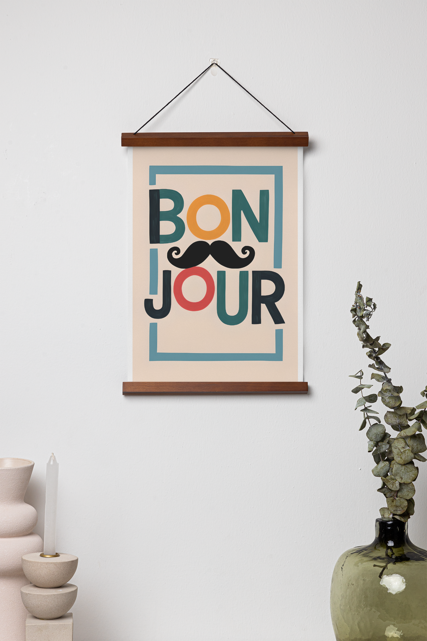 Framed 'Bonjour' poster with a mustache design on a white wall.
